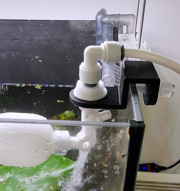 Auto fill float valve with black mounting bracket installed on aquarium for ATO water top-off system.