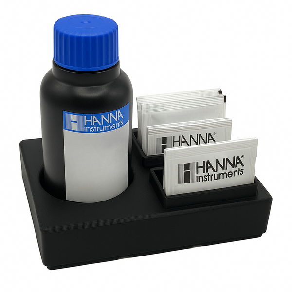 Black reagent organizer holding Hanna magnesium test kit components, including a reagent bottle with blue cap and white powder packets, displayed on a clean white background.